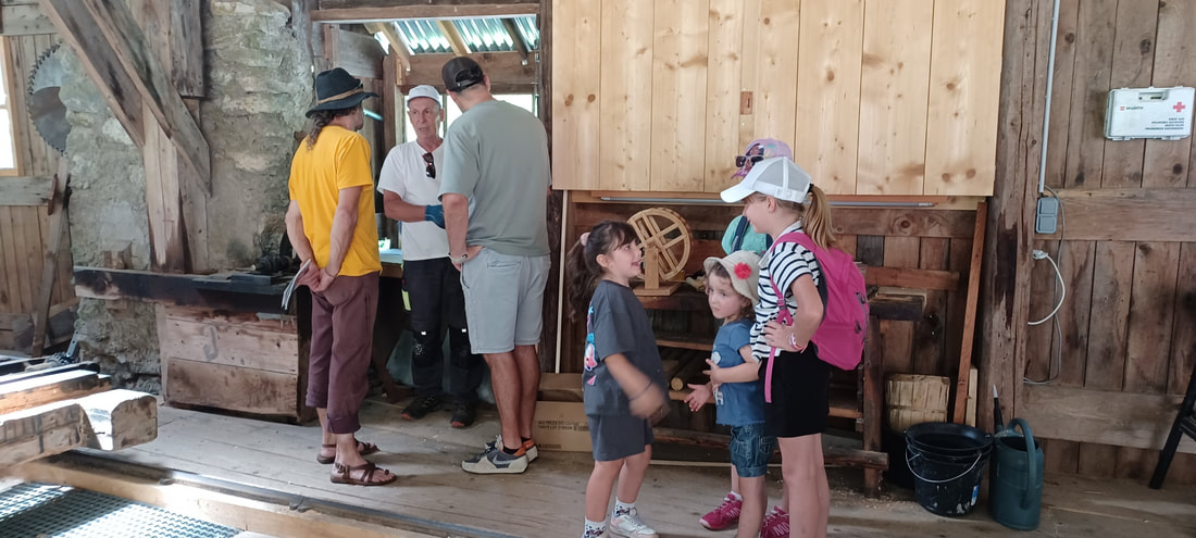 Élèves observant les poulies et les courroies de la scierie